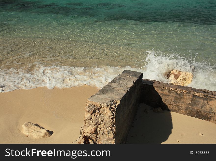 Bright blue water and rocks in the bahamas caribbean with waves splashing on the sand. Bright blue water and rocks in the bahamas caribbean with waves splashing on the sand