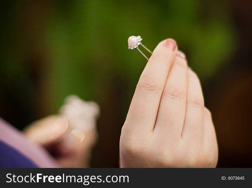 Hairpin with pearls in a female hand. Hairpin with pearls in a female hand