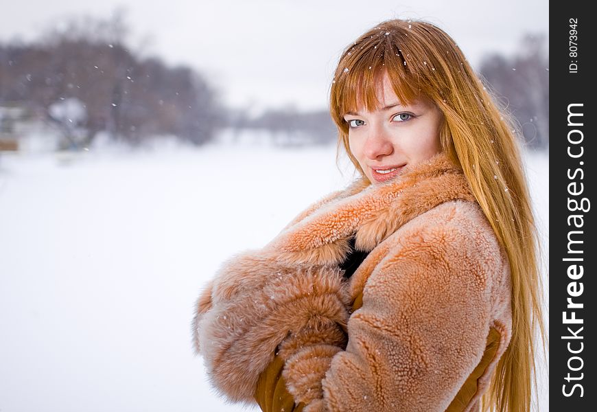 Red-heared girl in fur coat outdoors - shallow DOF. Red-heared girl in fur coat outdoors - shallow DOF