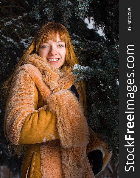 Red-heared girl in fur coat outdoors. Red-heared girl in fur coat outdoors