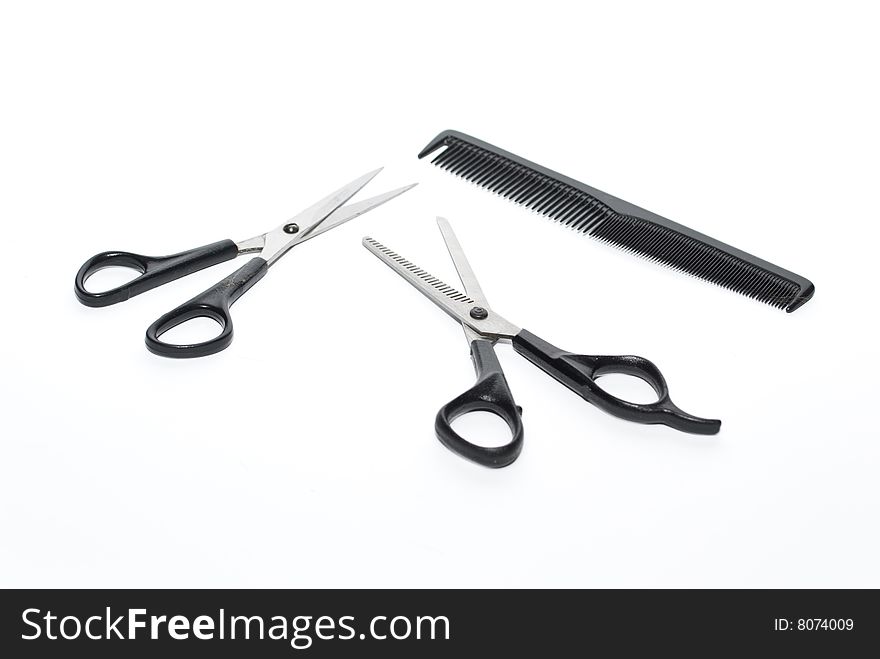 Scissors and comb on the white background