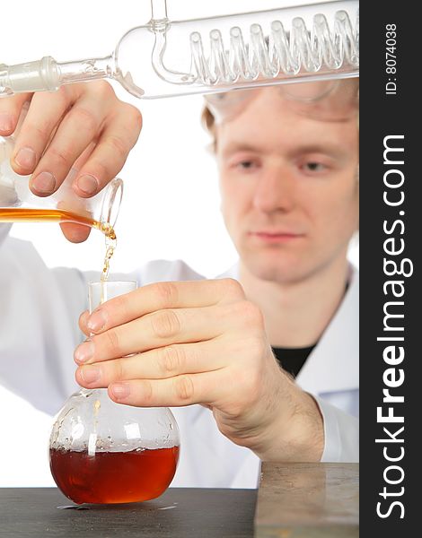 Chemist pours  brown liquid in flask