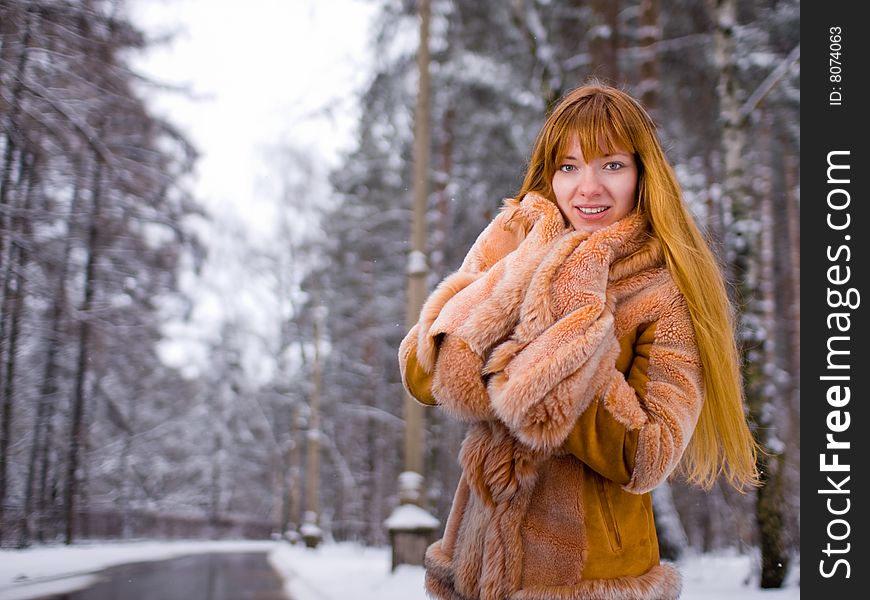 Red-heared girl in fur coat outdoors - shallow DOF. Red-heared girl in fur coat outdoors - shallow DOF