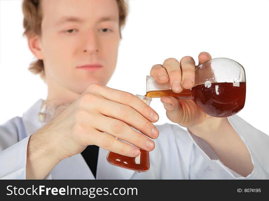 Chemist pours  brown liquid from one flask in another. Chemist pours  brown liquid from one flask in another