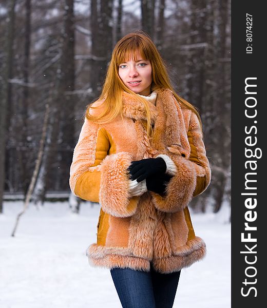 Red-heared girl in short fur coat outdoors - shallow DOF. Red-heared girl in short fur coat outdoors - shallow DOF