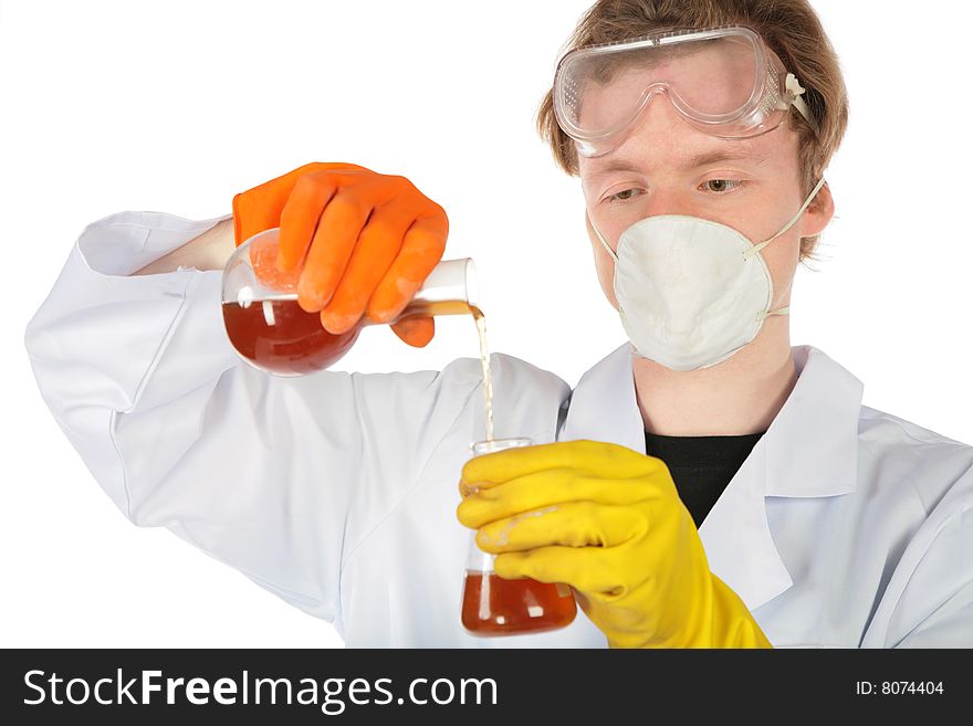 Scientist in respirator and rubber gloves pours brown liquid from one flask in another. Scientist in respirator and rubber gloves pours brown liquid from one flask in another