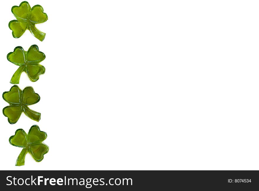 Four leaf clovers making a boarder on a white background.