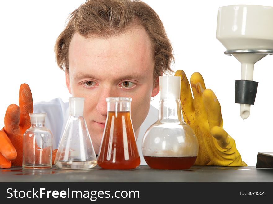 Chemist looks on flasks with liquids on white