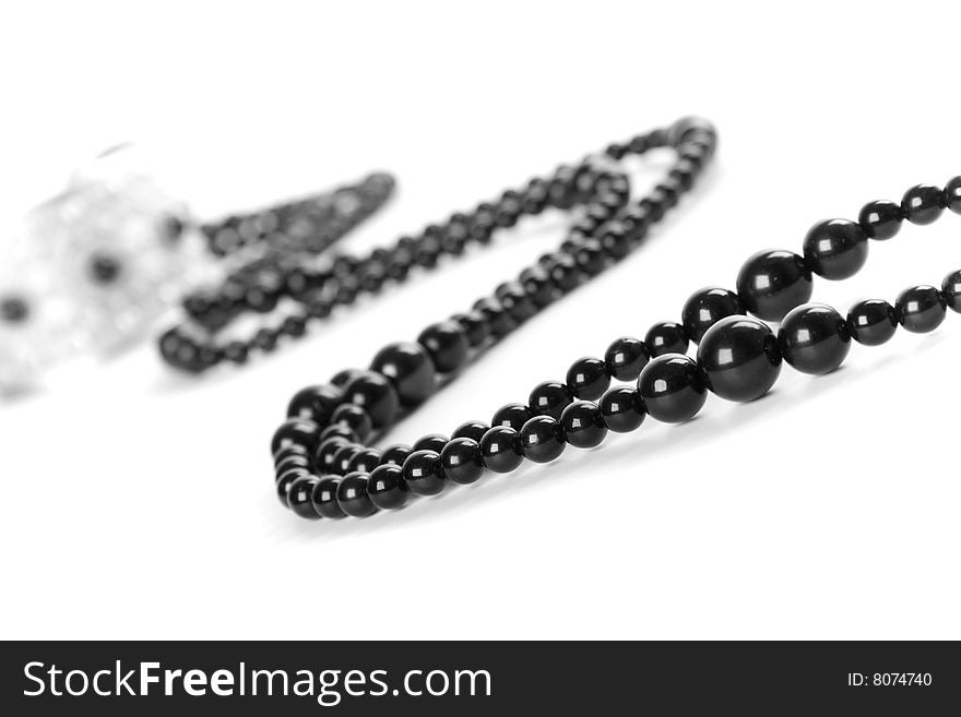 Bracelet and black necklace closeup on a white background