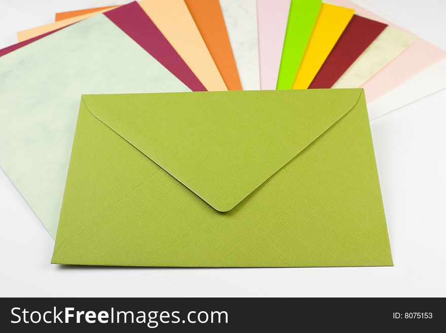 Colorful envelopes arranged in a fan shape with a green letter on top - copy space. Colorful envelopes arranged in a fan shape with a green letter on top - copy space.