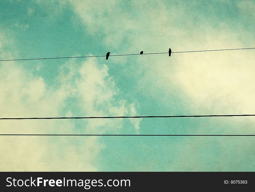 Three birds on a wire in a blue sky. Three birds on a wire in a blue sky