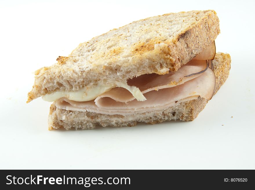 A cheese and turkey sandwich isolated on white