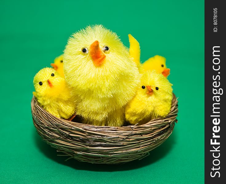 Craft / toy chicks in a nest. Green fabric background. Craft / toy chicks in a nest. Green fabric background.