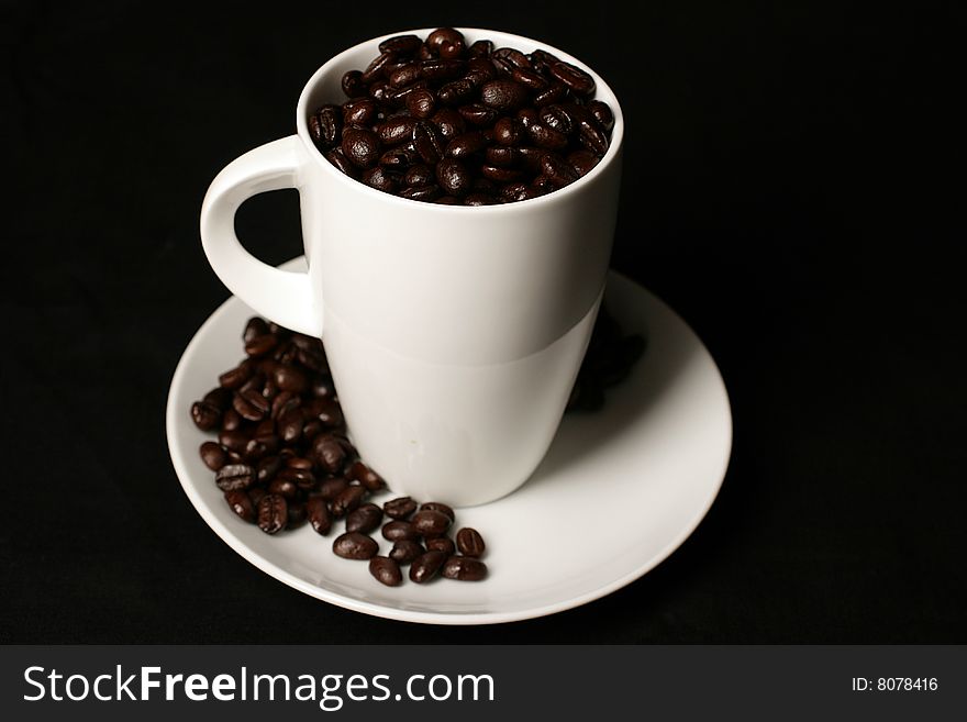 White Coffee cup and coffee beans on black background. White Coffee cup and coffee beans on black background