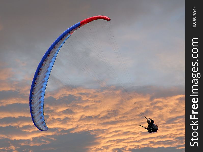 A man making a parachute jump in the sunset. A man making a parachute jump in the sunset