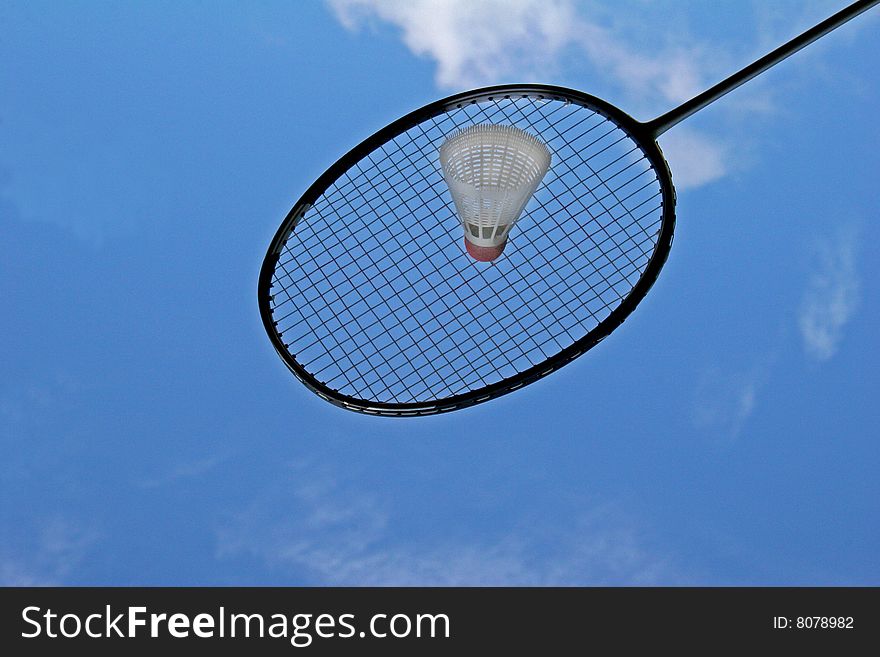 Badminton racket and shuttlecock against blue sky