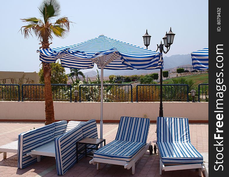 Empty deckchairs wait tourists. Fragment of territory of hotel