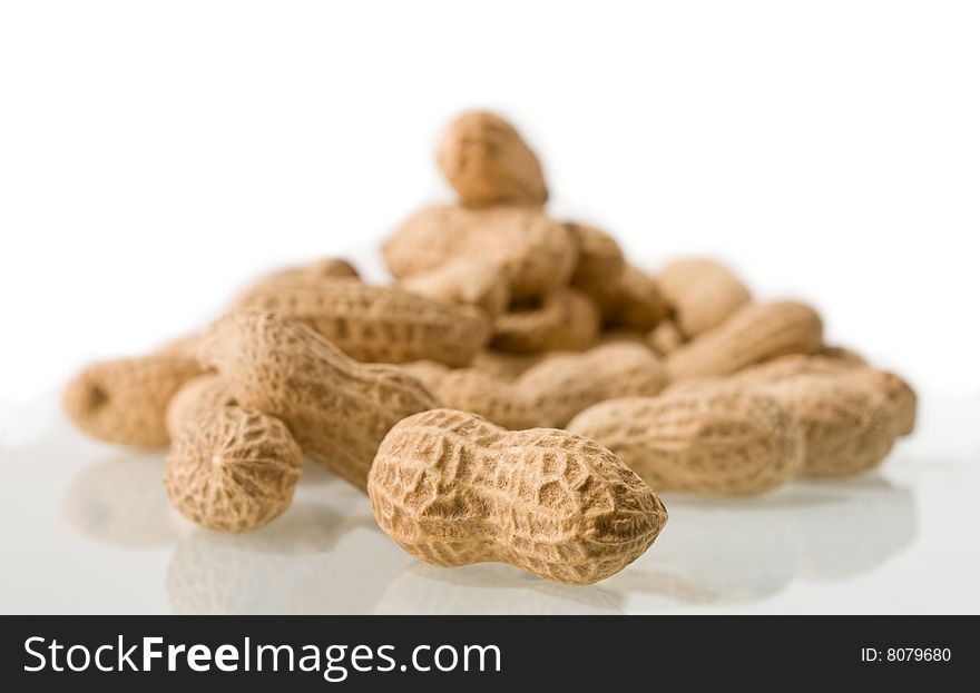 Peanuts in the skin with a reflection on a white background