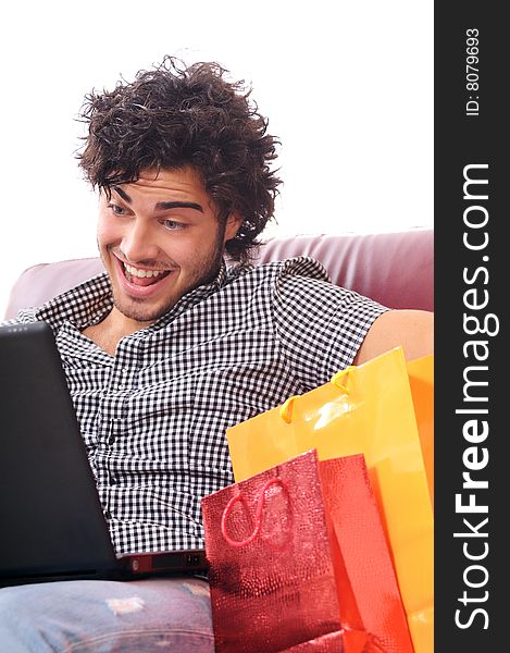 A young man using his credit card to purchase over the internet, happiness and amazement. A young man using his credit card to purchase over the internet, happiness and amazement