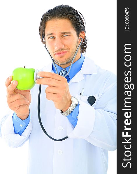 Young doctor showing unhappy expression checking on green apple. Young doctor showing unhappy expression checking on green apple