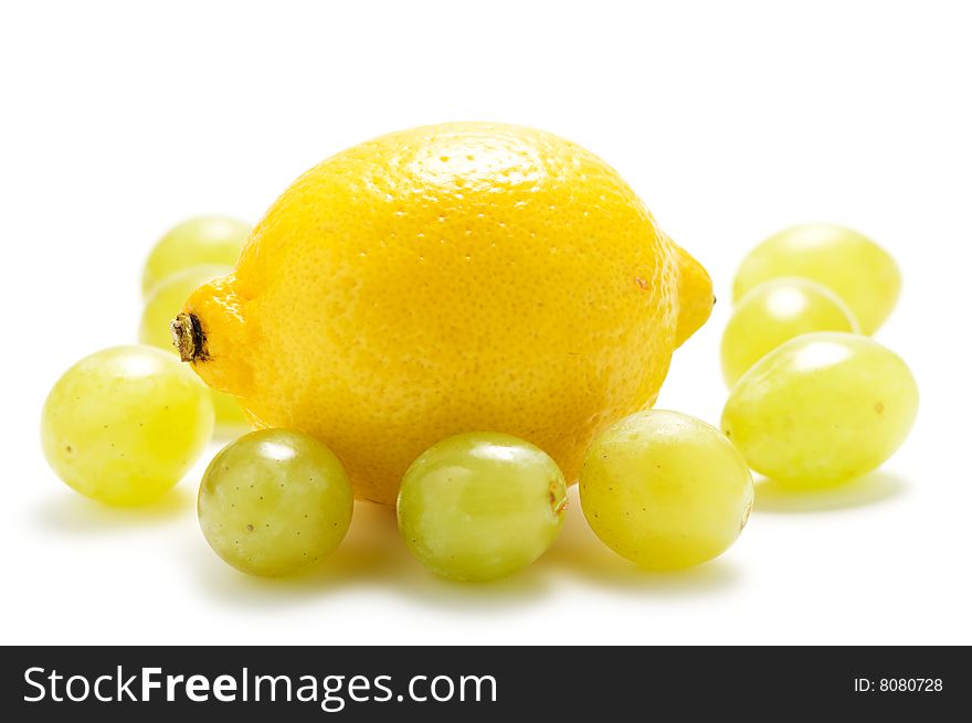 Yellow lemon and green grape isolated on a white background. Yellow lemon and green grape isolated on a white background.