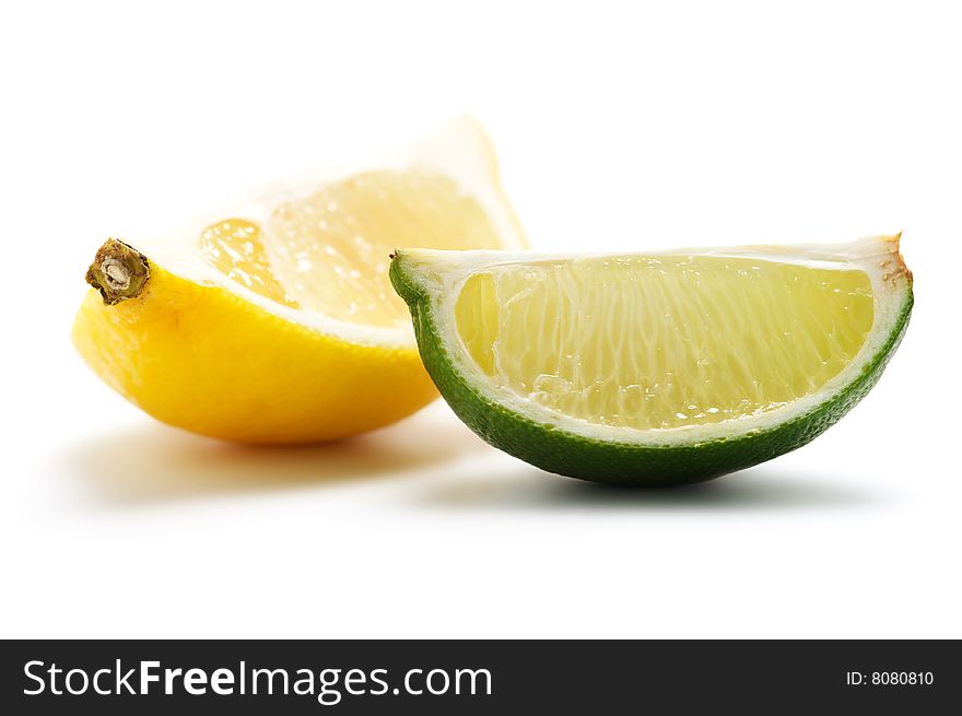 Two pieces of lime and lemon isolated on a white background. Background blurry.