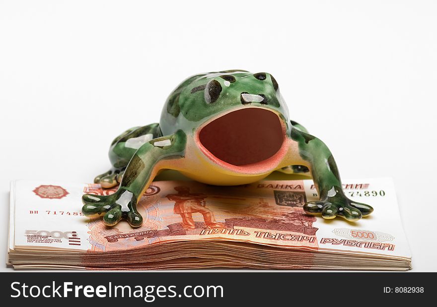 frog on a pile of  denominations