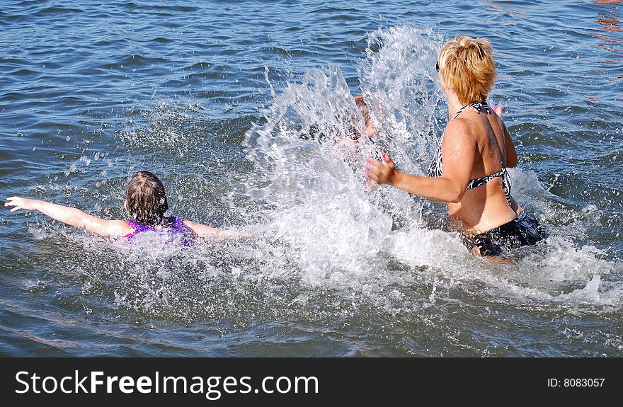 A mom plays with her children in the water. A mom plays with her children in the water