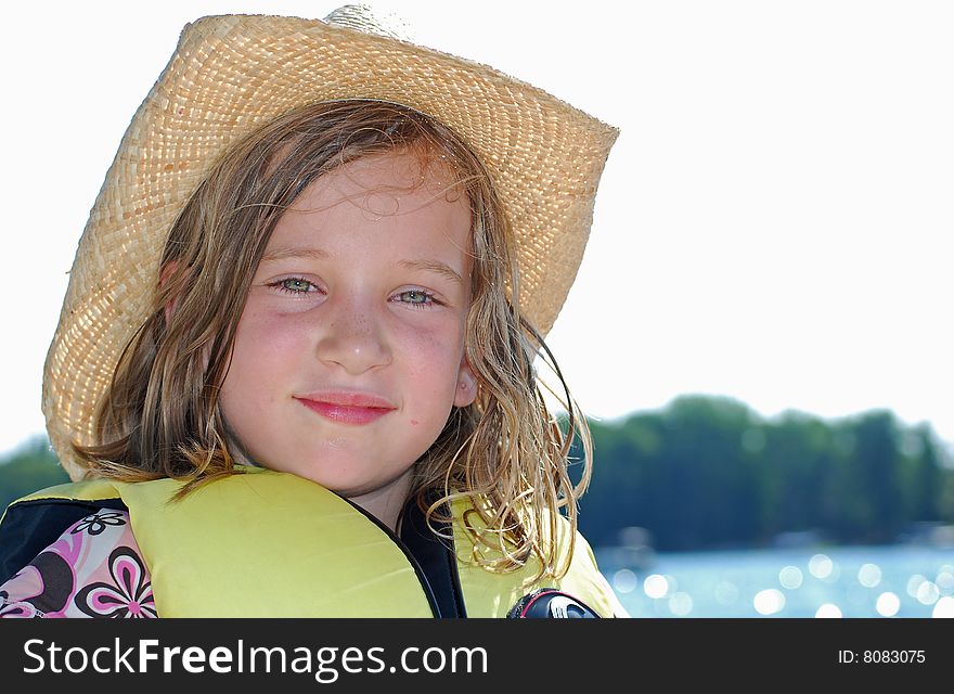 A little girl in a cowboy hat enjoys a day at the beach. A little girl in a cowboy hat enjoys a day at the beach