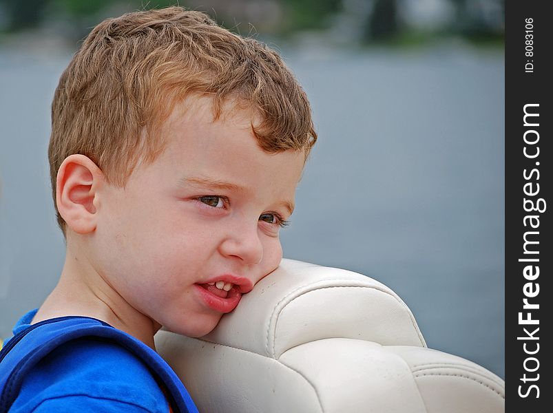 A little boy relaxes on a boat ride. A little boy relaxes on a boat ride