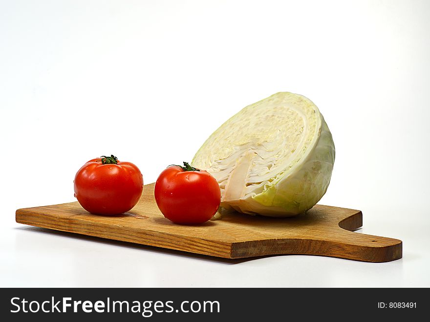 Cabbage and tomato on wooden plate