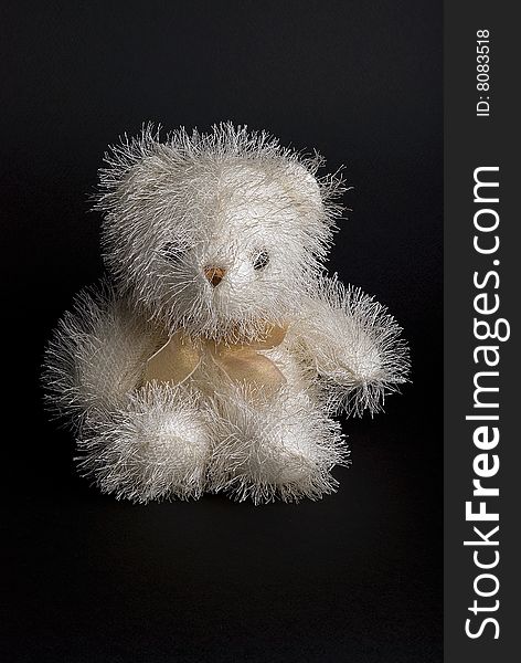 White downy bear toy isolated on a black background. White downy bear toy isolated on a black background