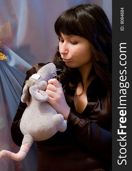 A girl holds a toy - funny rat. A girl holds a toy - funny rat