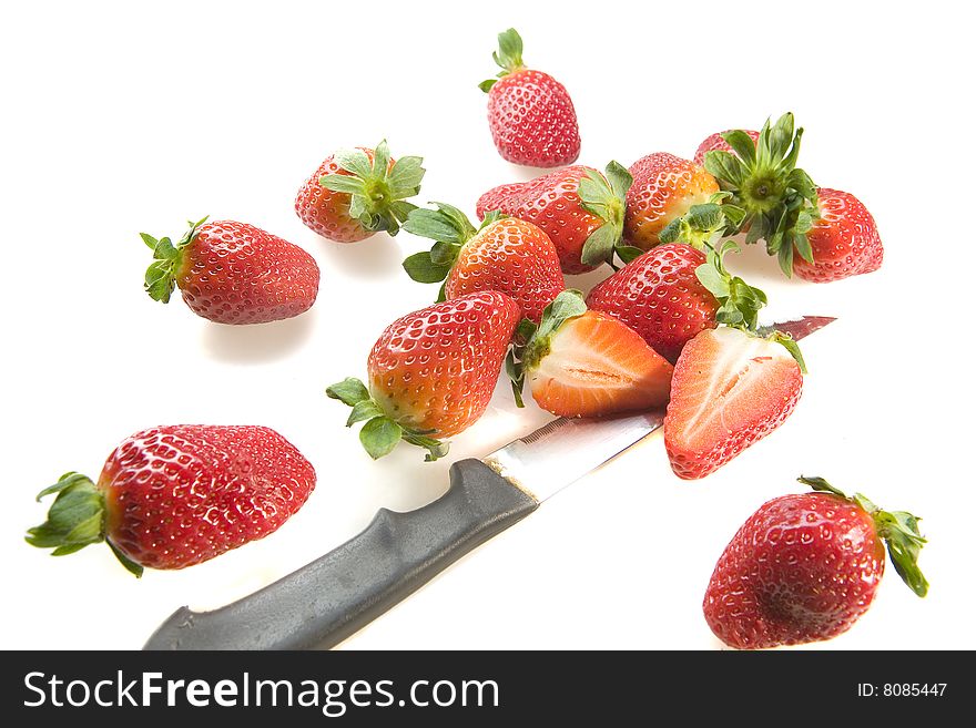 Fresh Strawberries with knife on white ground