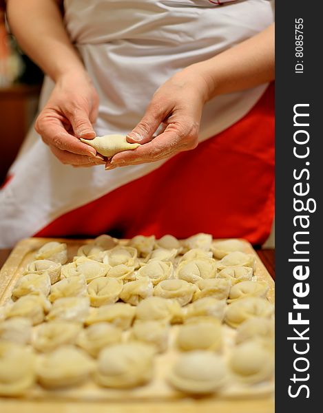 Woman making russian dumplings (pelmeni)