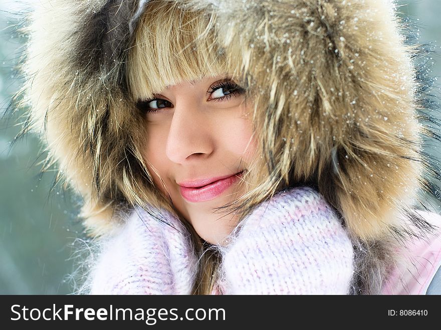 Portrait of a beautiful young smiling woman having a walk in the winter park. Portrait of a beautiful young smiling woman having a walk in the winter park