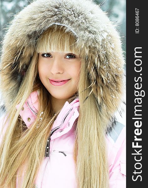 Portrait of a beautiful young woman with long blond hair having a walk in winter park. Portrait of a beautiful young woman with long blond hair having a walk in winter park