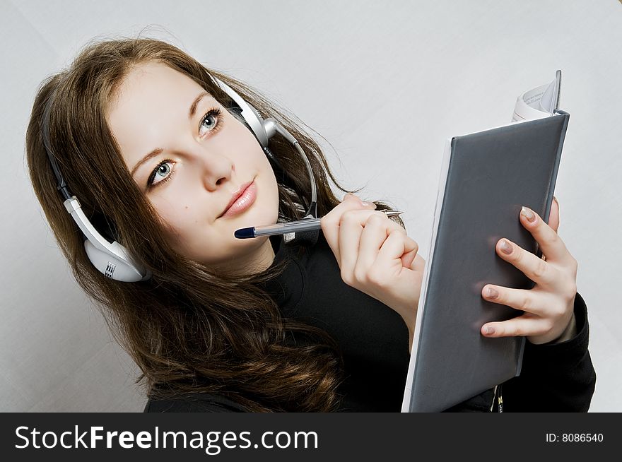 Beautiful girl in headphones and notebook