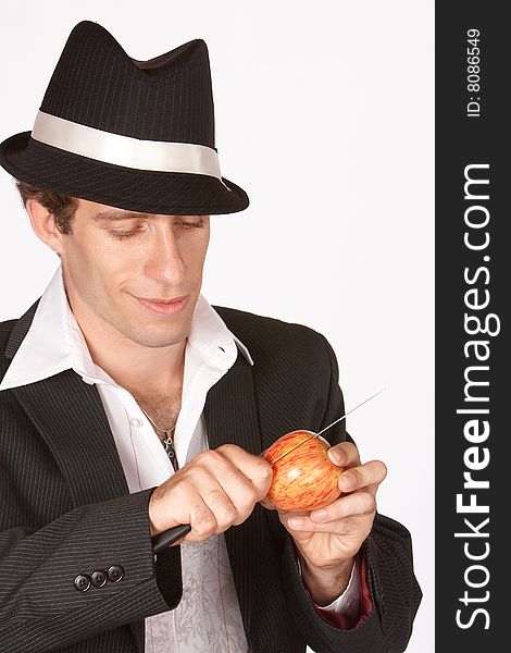 Man slicing apple with knife wearing a suit