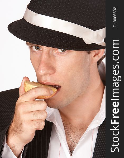 Young male eating an apple that has been sliced in halve