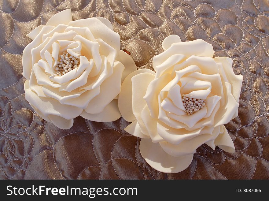 Imitation of roses in champagne color on brown background. Imitation of roses in champagne color on brown background