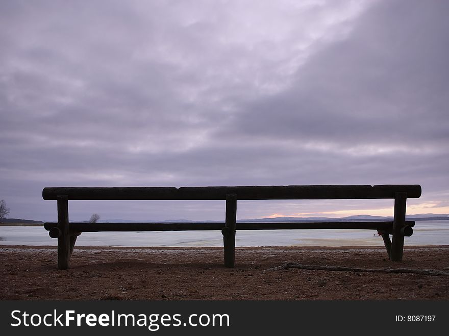 Park bench with a frozen lake in the background