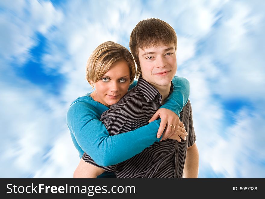 Young couple hugging (blue sky background)