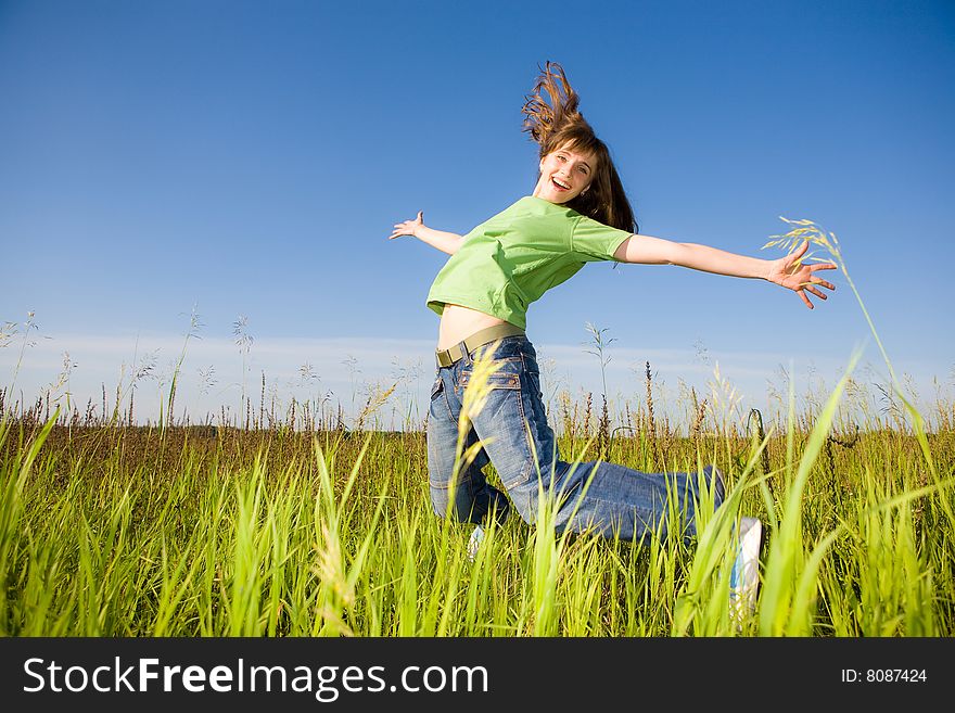 Happy jumping young woman. blue sky.