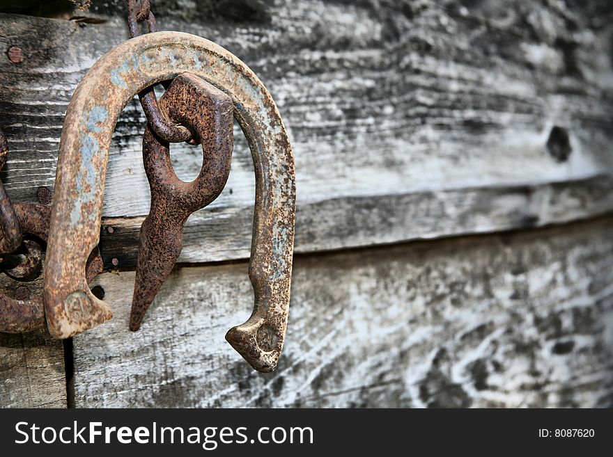 Old Rusted Horseshoe and Log Splitter against Weathered Board Background