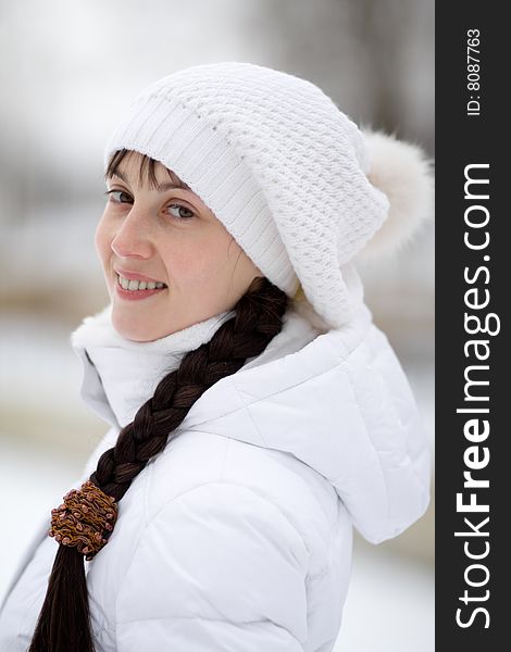 Smiling winter girl in white cap - shallow DOF