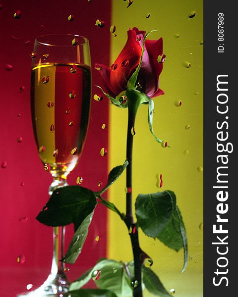 Red Rose with a glass of champagne on the red-green background. Red Rose with a glass of champagne on the red-green background