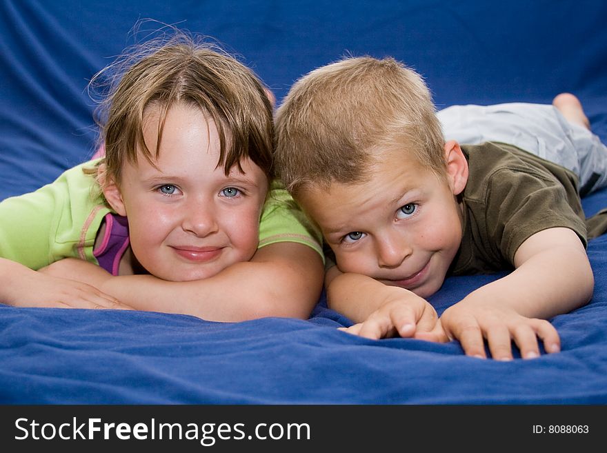 Kids laying on a blue bed. Kids laying on a blue bed