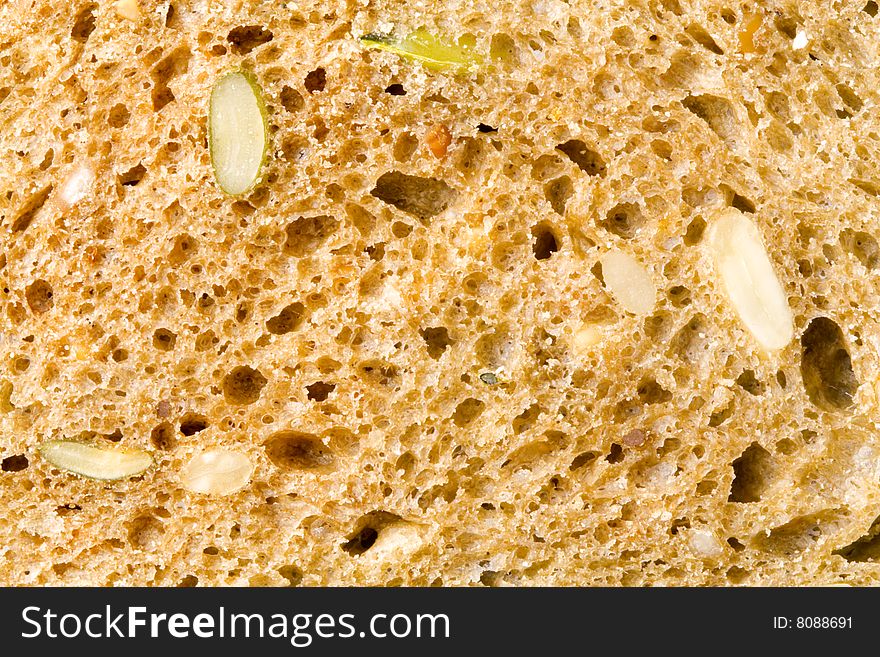 A close up of the texture of a slice of brown bread. A close up of the texture of a slice of brown bread