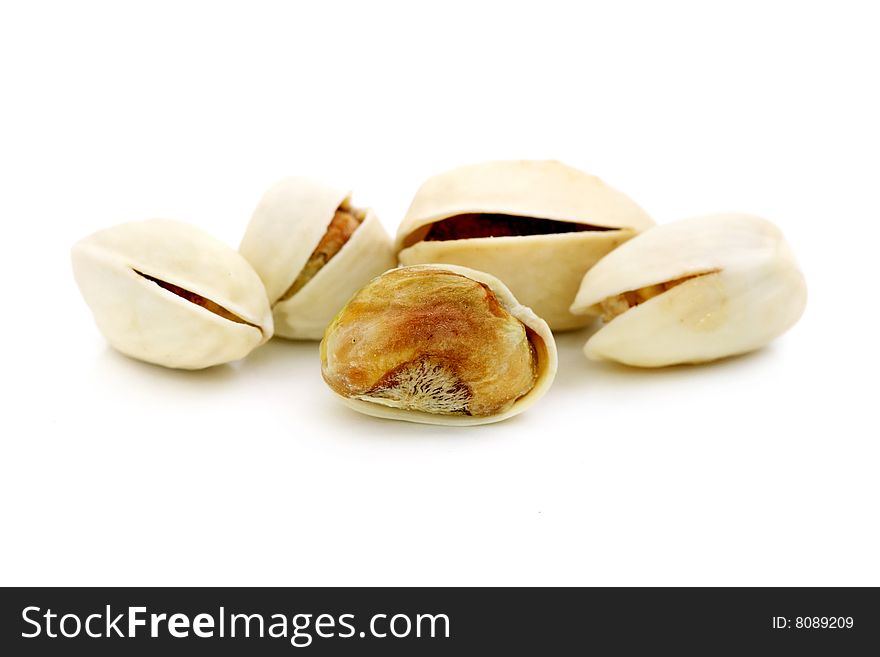 Pistachio nuts arranged in a row over white background.